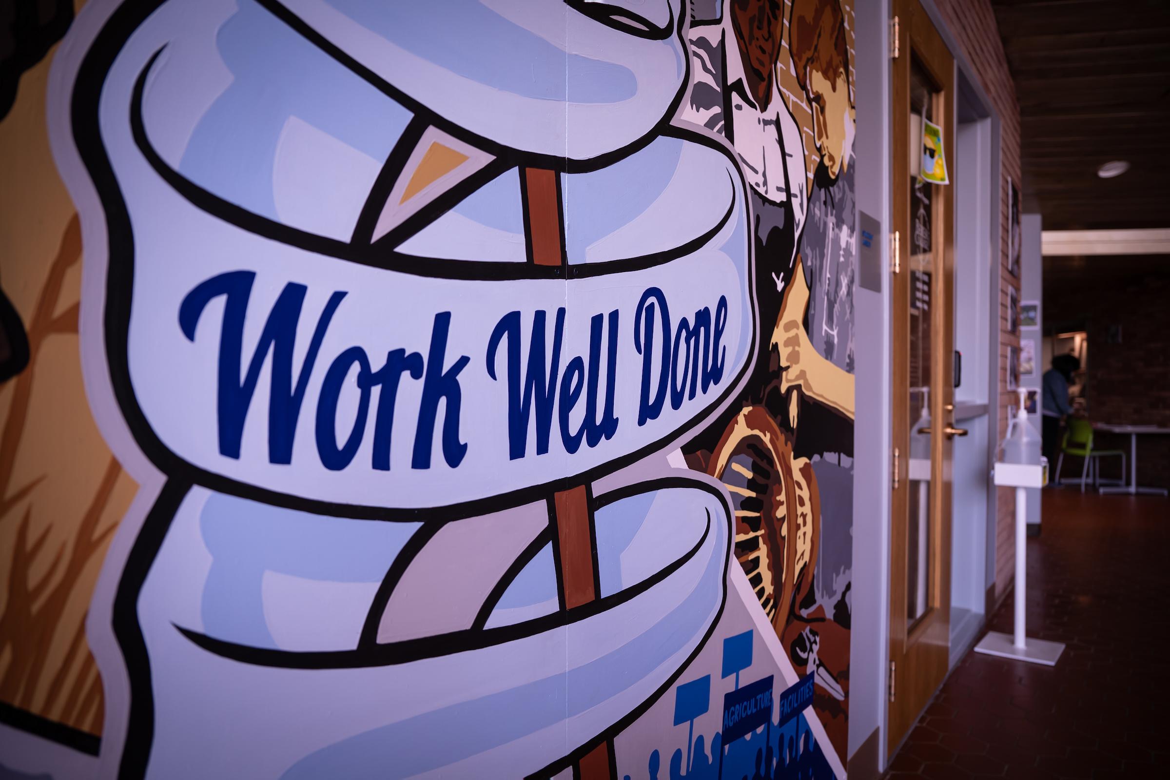 A mural besides the Labor Program Office, which reads "Work well done"